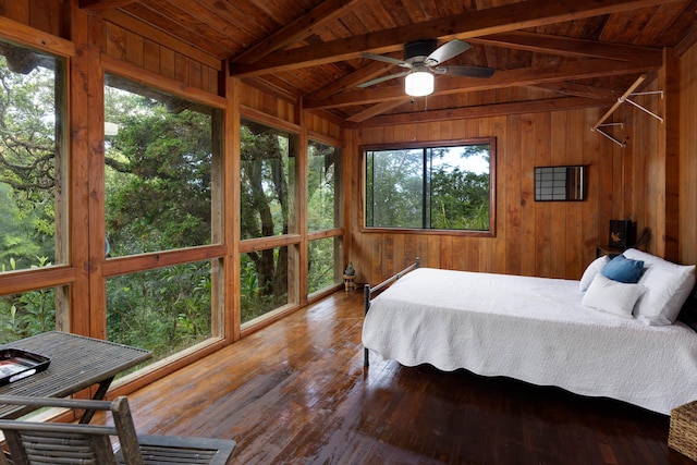 bedroom with multiple windows, lofted ceiling with beams, ceiling fan, and wood-type flooring