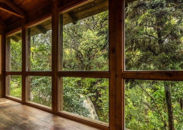 unfurnished sunroom with beam ceiling and wooden ceiling