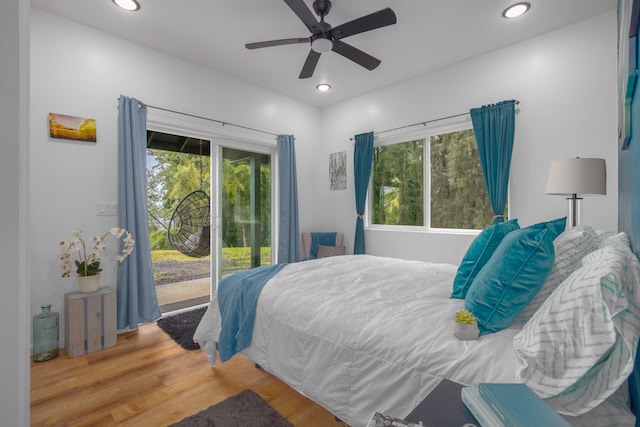 bedroom with access to outside, multiple windows, ceiling fan, and hardwood / wood-style floors