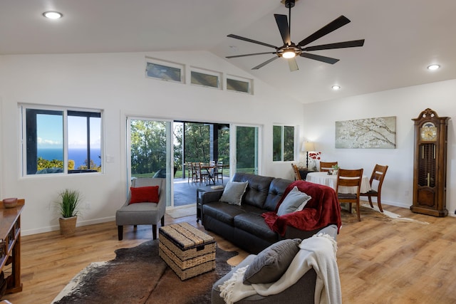 living room with ceiling fan, high vaulted ceiling, and light wood-type flooring