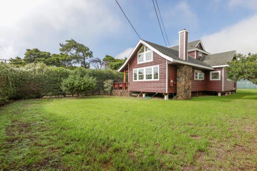 rear view of property featuring a deck and a yard