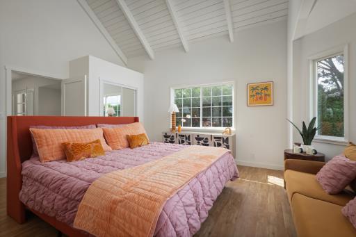 bedroom with beam ceiling, wood-type flooring, and high vaulted ceiling