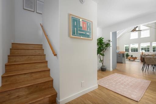 staircase with hardwood / wood-style floors and lofted ceiling