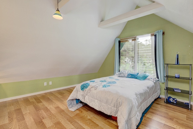 bedroom with lofted ceiling with beams and hardwood / wood-style flooring