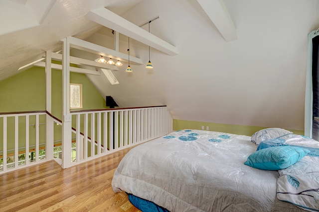 bedroom featuring vaulted ceiling with beams and light wood-type flooring