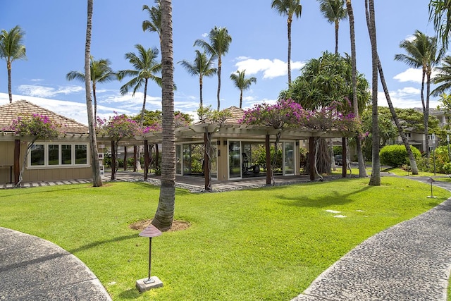 view of community featuring a pergola and a yard