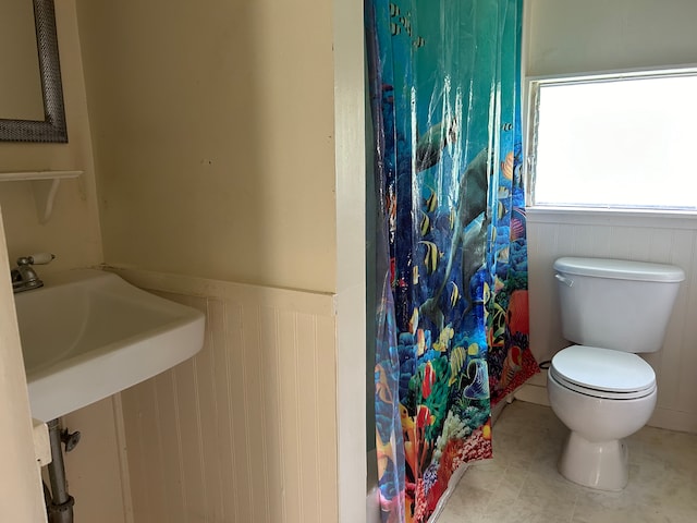 bathroom with a shower with shower curtain and toilet