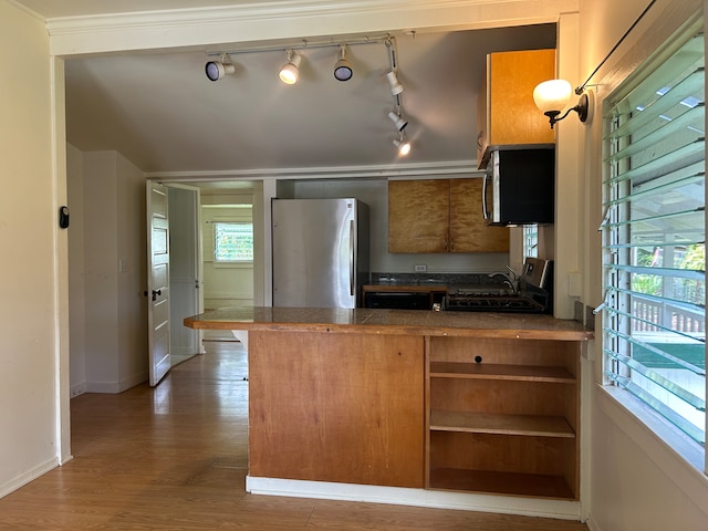 kitchen featuring dark hardwood / wood-style flooring, rail lighting, ornamental molding, stainless steel appliances, and sink