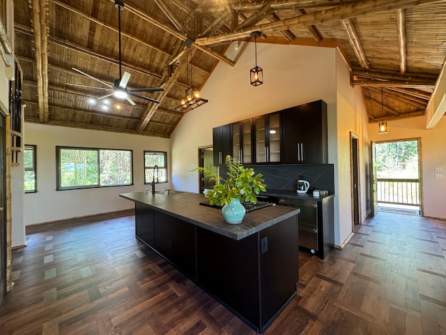 kitchen featuring a center island, high vaulted ceiling, ceiling fan with notable chandelier, beamed ceiling, and wood ceiling