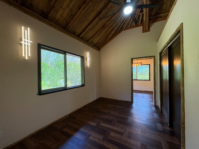 empty room with vaulted ceiling, ceiling fan, dark wood-type flooring, and wood ceiling