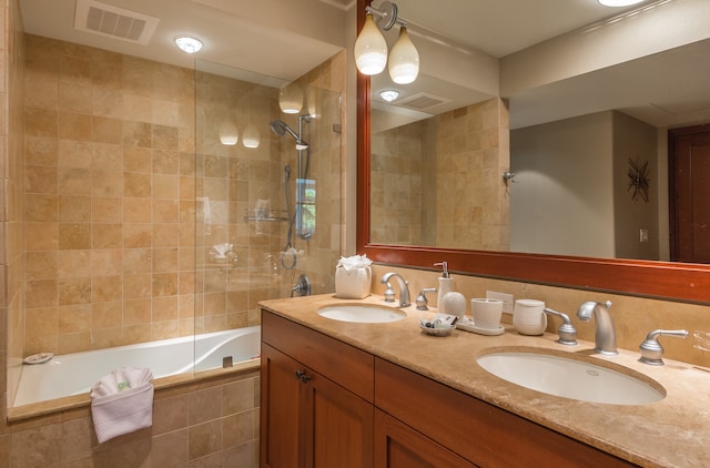 bathroom featuring tiled shower / bath combo and vanity