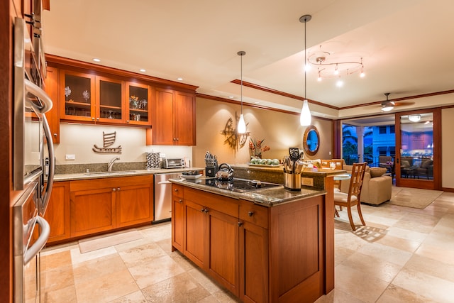 kitchen featuring sink, hanging light fixtures, dark stone countertops, an island with sink, and appliances with stainless steel finishes