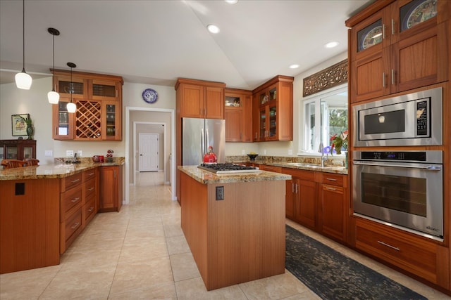 kitchen featuring light stone countertops, stainless steel appliances, decorative light fixtures, a center island, and light tile patterned flooring