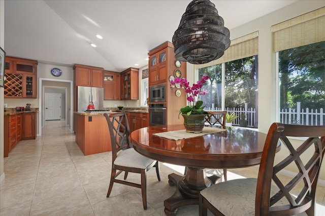 dining area featuring light tile patterned floors and vaulted ceiling