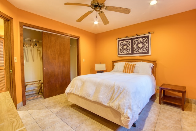 tiled bedroom with ceiling fan and a closet