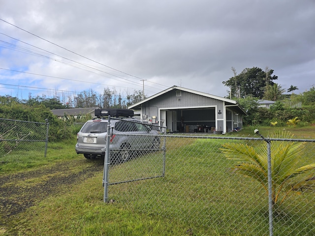 exterior space with a garage, driveway, a lawn, and fence