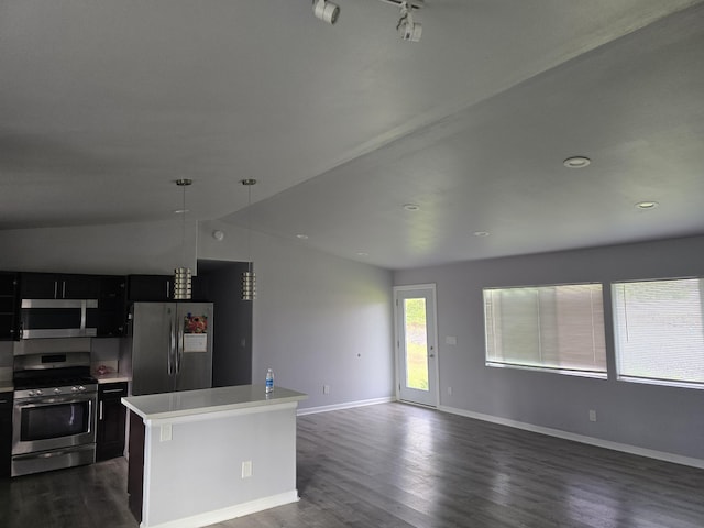 kitchen featuring decorative light fixtures, a center island, stainless steel appliances, dark cabinetry, and light countertops