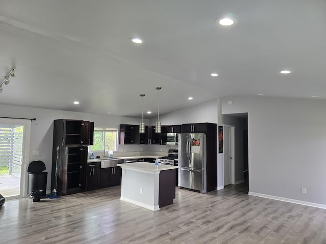 kitchen featuring decorative light fixtures, light wood finished floors, light countertops, appliances with stainless steel finishes, and a kitchen island