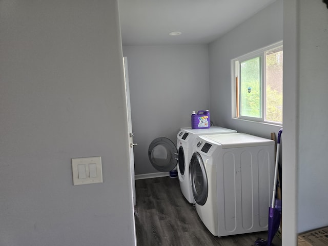 clothes washing area featuring laundry area, washer and clothes dryer, dark wood finished floors, and baseboards