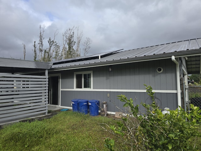 view of side of property featuring metal roof and solar panels