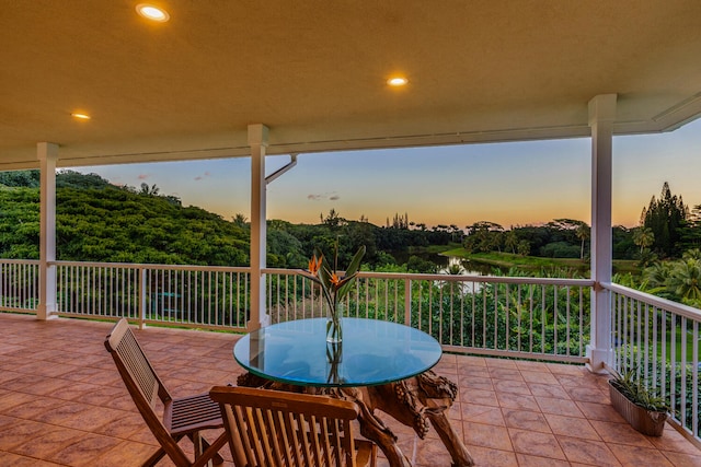 patio terrace at dusk with a balcony and a water view