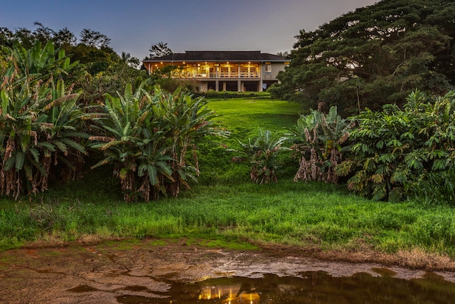 yard at dusk featuring a water view