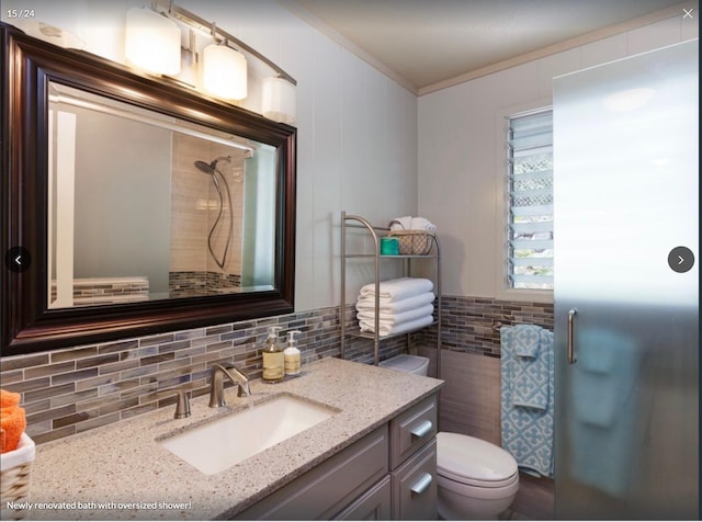 bathroom featuring decorative backsplash, vanity, crown molding, tile walls, and toilet