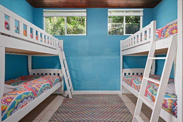 tiled bedroom with multiple windows and wooden ceiling