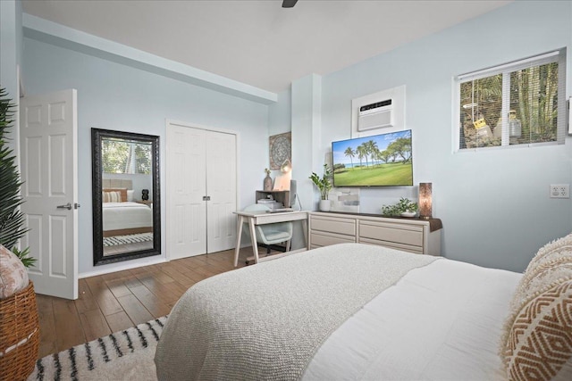 bedroom featuring a closet, dark hardwood / wood-style floors, multiple windows, and ceiling fan