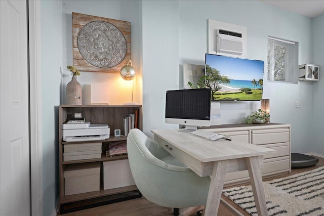 office with a wall mounted air conditioner and wood-type flooring