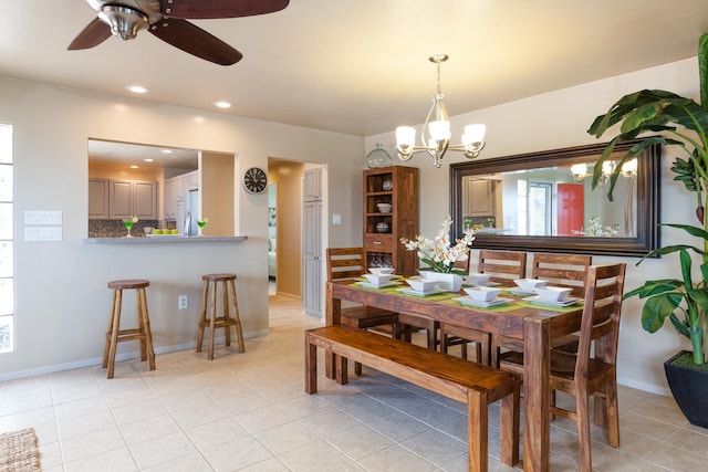 tiled dining space featuring ceiling fan with notable chandelier