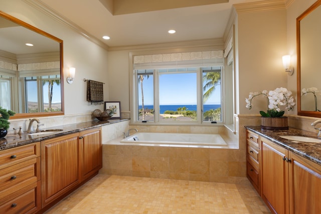 bathroom featuring vanity, a water view, crown molding, and tiled tub