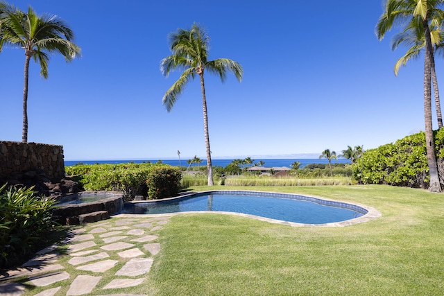 view of pool featuring an in ground hot tub, a water view, and a lawn