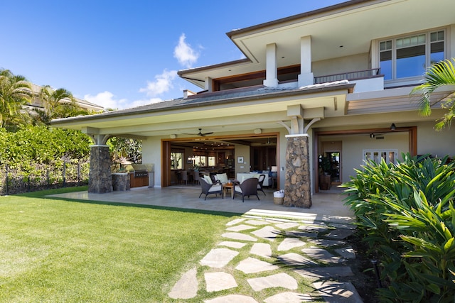 back of house with an outdoor hangout area, ceiling fan, a balcony, a yard, and a patio area