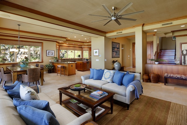 tiled living room featuring ceiling fan with notable chandelier and ornamental molding