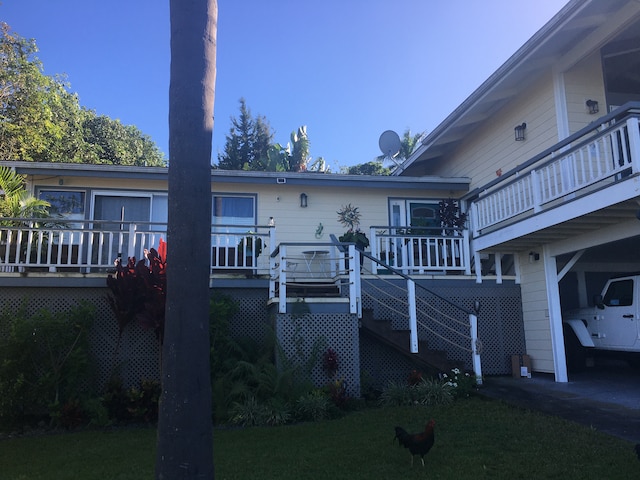 back of house with a wooden deck and a yard