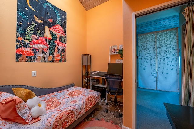 carpeted bedroom with lofted ceiling