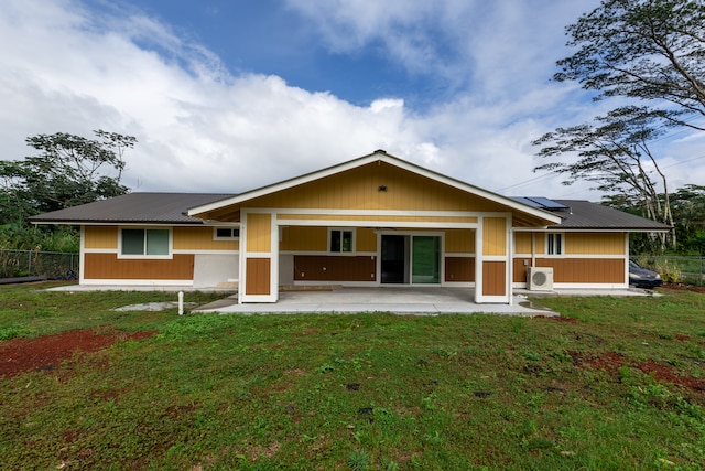 view of front facade with a patio area, ac unit, a front yard, and solar panels