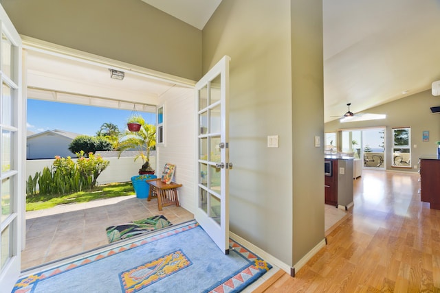 entryway with lofted ceiling, light hardwood / wood-style flooring, and french doors