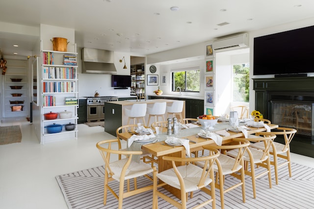 dining room featuring a wall unit AC and sink