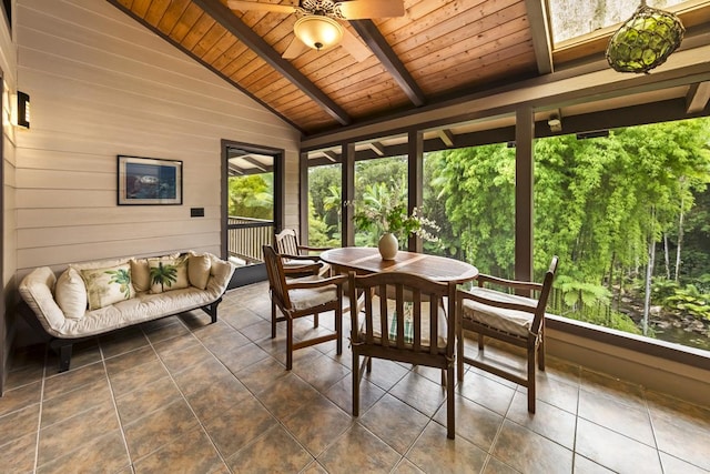 sunroom featuring a healthy amount of sunlight, vaulted ceiling with beams, ceiling fan, and wood ceiling