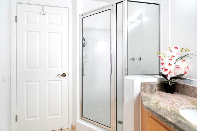 bathroom featuring vanity and a shower with shower door