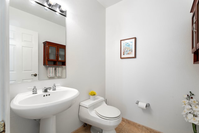 bathroom featuring tile patterned floors, toilet, and sink