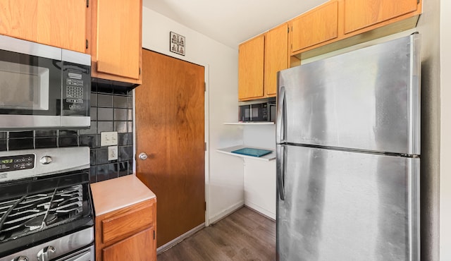 kitchen with backsplash, dark wood-type flooring, and stainless steel appliances