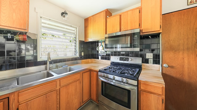 kitchen featuring appliances with stainless steel finishes, backsplash, and sink