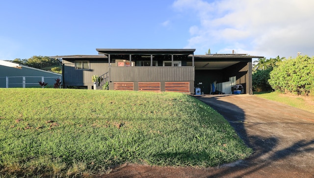 view of front of home with a front yard and a carport