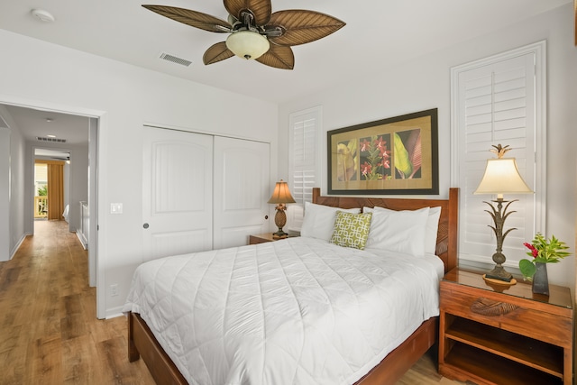 bedroom with ceiling fan, wood-type flooring, and a closet