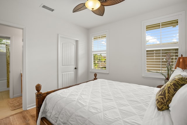 bedroom with hardwood / wood-style flooring, multiple windows, and ceiling fan