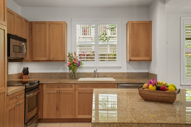 kitchen with light tile patterned floors, stainless steel appliances, and sink