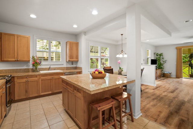 kitchen featuring plenty of natural light, a kitchen island, appliances with stainless steel finishes, and a chandelier